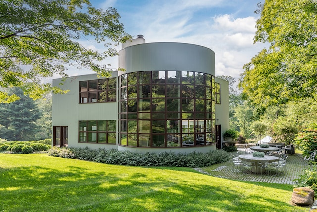 rear view of property with a yard and a patio