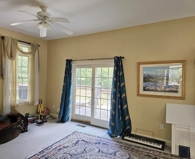 doorway with carpet floors, a wealth of natural light, and ceiling fan