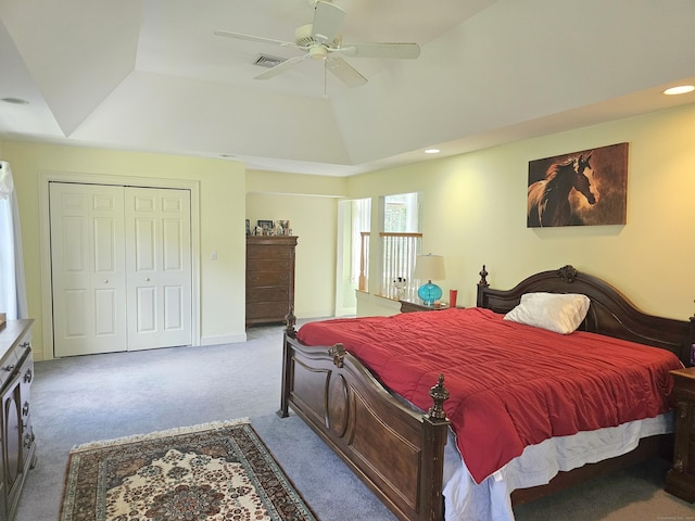 carpeted bedroom featuring a raised ceiling, lofted ceiling, ceiling fan, and a closet