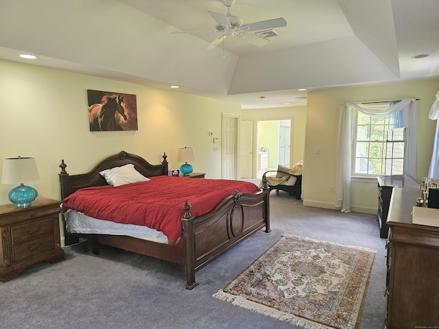 carpeted bedroom featuring a raised ceiling, lofted ceiling, and ceiling fan