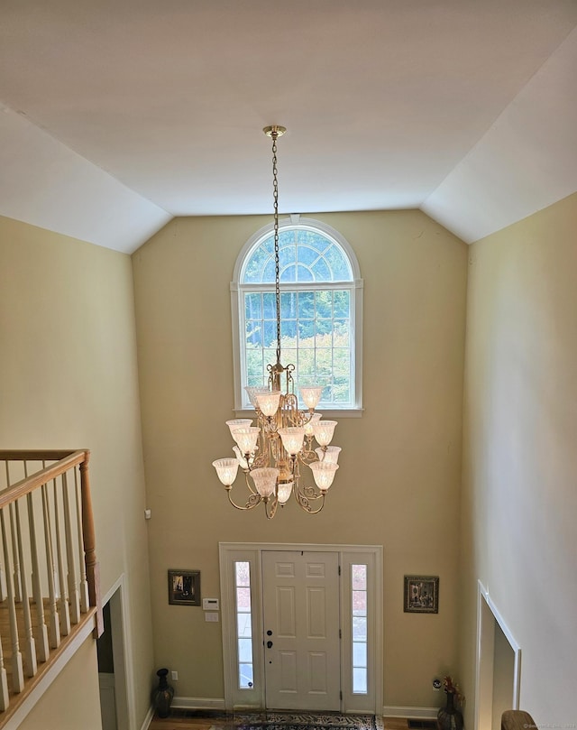 entryway with a notable chandelier and vaulted ceiling