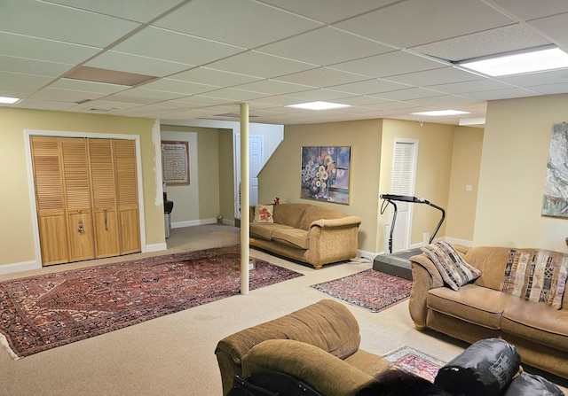 carpeted living room with a drop ceiling