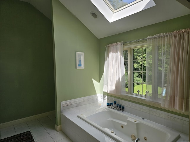 bathroom featuring a relaxing tiled tub, tile patterned floors, and vaulted ceiling with skylight