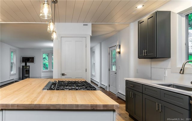 kitchen with butcher block countertops, hardwood / wood-style flooring, pendant lighting, and a center island