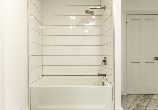 bathroom with tiled shower / bath and hardwood / wood-style floors