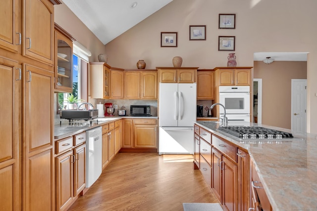 15 Huntington Ridge Rd, Wallingford, CT 06492 - kitchen with stainless steel appliances, high vaulted ceiling, decorative backsplash, light wood-type flooring, and glass insert cabinets
