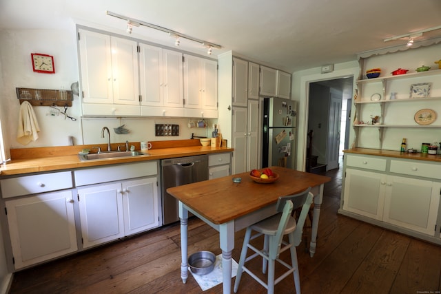 kitchen featuring white cabinets, stainless steel appliances, sink, dark hardwood / wood-style floors, and rail lighting