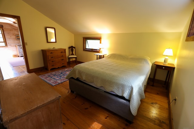 bedroom with vaulted ceiling and hardwood / wood-style flooring