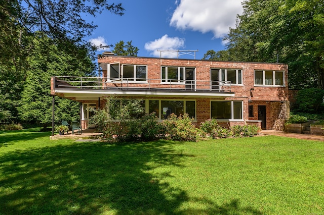 view of front of property with covered porch, a balcony, and a front yard