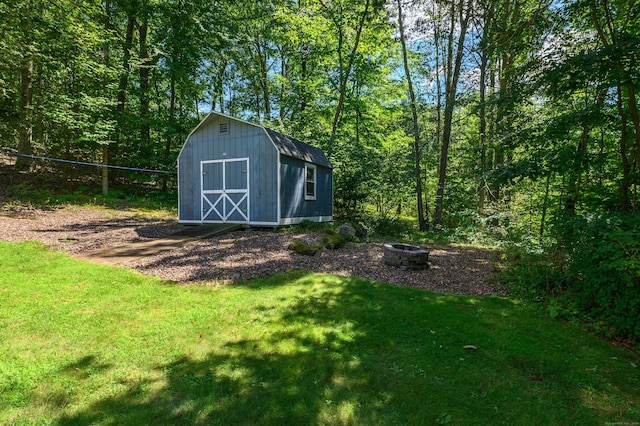 view of yard with a shed and an outdoor fire pit