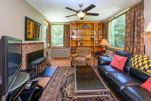 living room with plenty of natural light, ceiling fan, hardwood / wood-style floors, and radiator heating unit