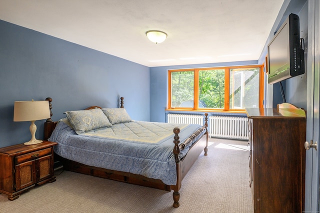 bedroom with radiator heating unit and light carpet