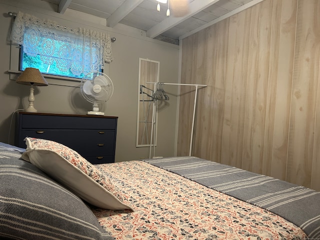 bedroom with beam ceiling, ceiling fan, wood walls, and wooden ceiling