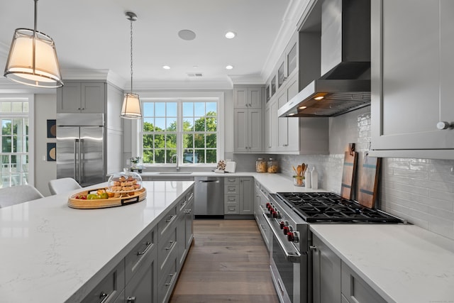 kitchen featuring decorative backsplash, high quality appliances, wall chimney exhaust hood, ornamental molding, and sink