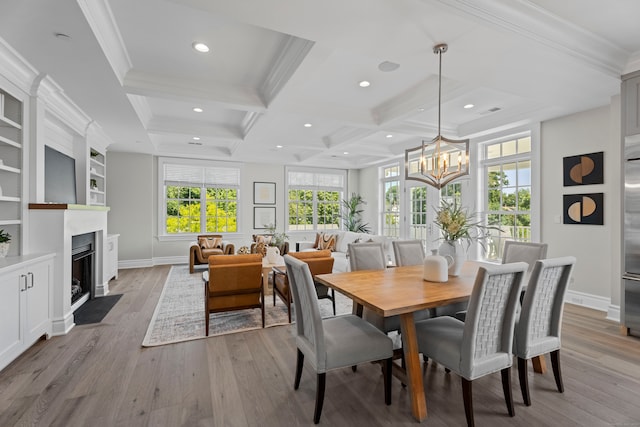 dining room with coffered ceiling, crown molding, light wood-type flooring, and beamed ceiling