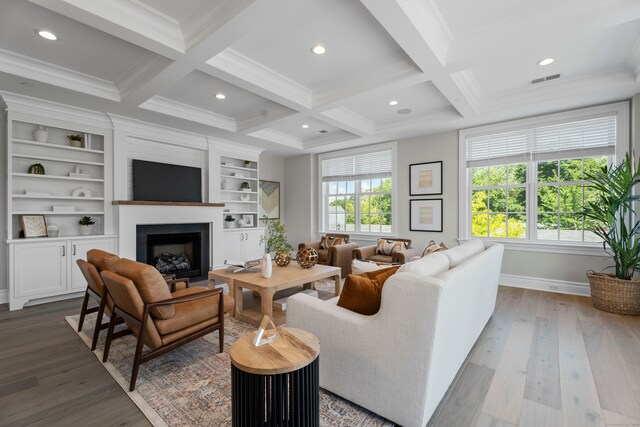 living room featuring light hardwood / wood-style flooring, built in shelves, coffered ceiling, and beamed ceiling