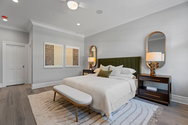 bedroom with ceiling fan, ornamental molding, and wood-type flooring