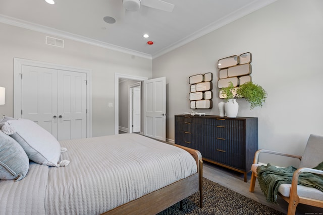 bedroom with ceiling fan, crown molding, hardwood / wood-style flooring, and a closet