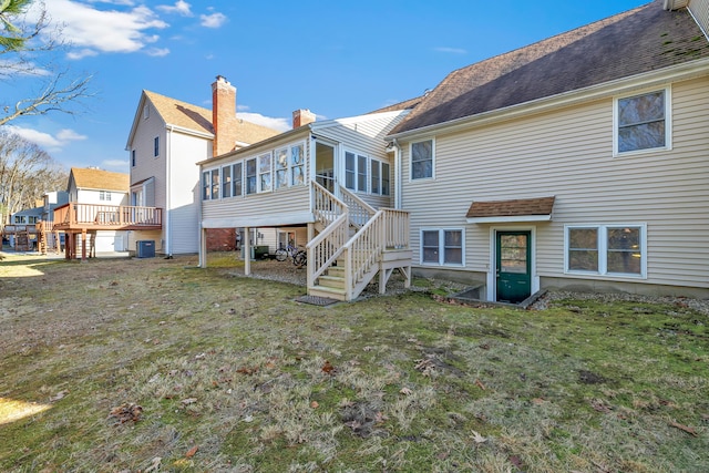 back of property featuring stairway, central AC unit, a lawn, and a sunroom