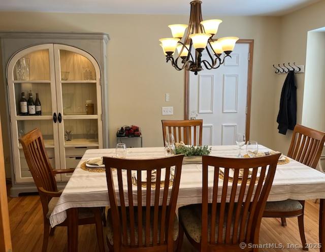 dining area with a notable chandelier and wood finished floors