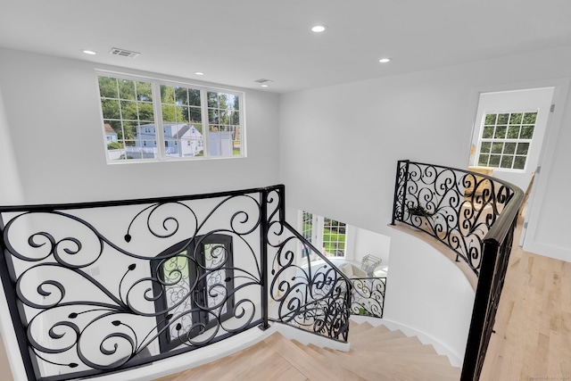 staircase with hardwood / wood-style floors and plenty of natural light