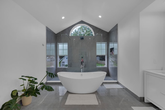 bathroom with vanity, lofted ceiling, tile walls, and shower with separate bathtub