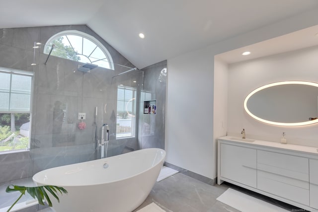 bathroom with lofted ceiling, vanity, and independent shower and bath