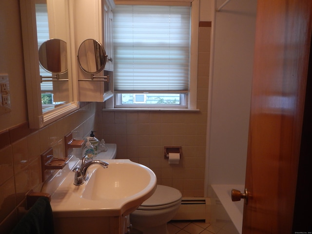 bathroom with toilet, a baseboard radiator, tile walls, tile patterned floors, and sink