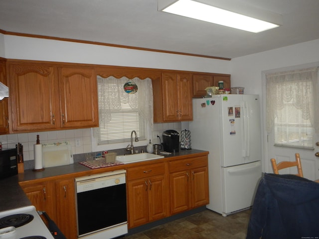 kitchen featuring decorative backsplash, dishwasher, sink, and white refrigerator