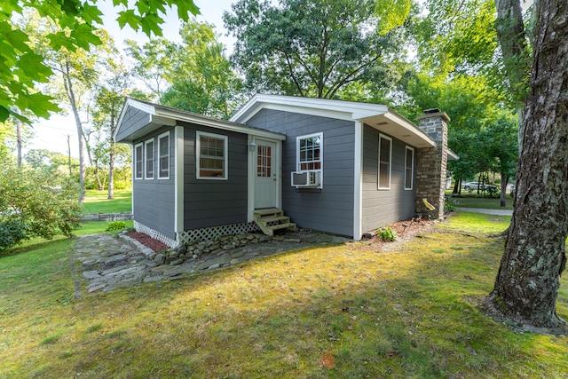 view of outdoor structure with cooling unit and a lawn