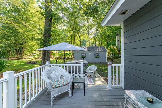 wooden terrace featuring a yard and an outdoor structure