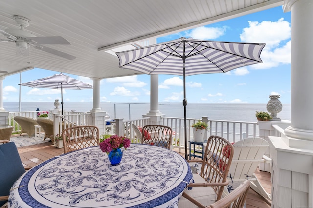 deck with ceiling fan and a water view