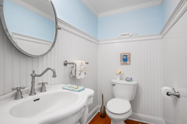 bathroom featuring toilet, crown molding, hardwood / wood-style floors, and sink