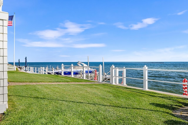 view of dock with a water view and a lawn