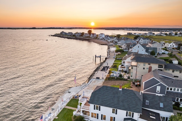 aerial view at dusk featuring a water view