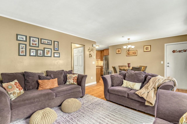 living room featuring light hardwood / wood-style floors, a chandelier, and crown molding