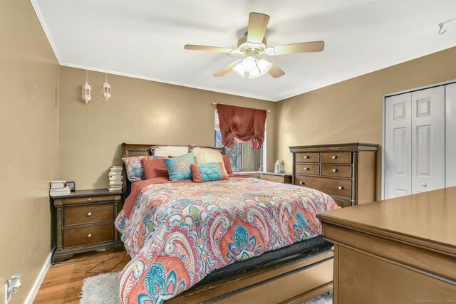 bedroom with light hardwood / wood-style floors, ceiling fan, and a closet