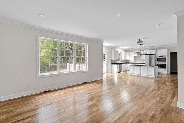 289 Young St, East Hampton, CT 06424 - unfurnished living room with light wood finished floors, visible vents, crown molding, and baseboards