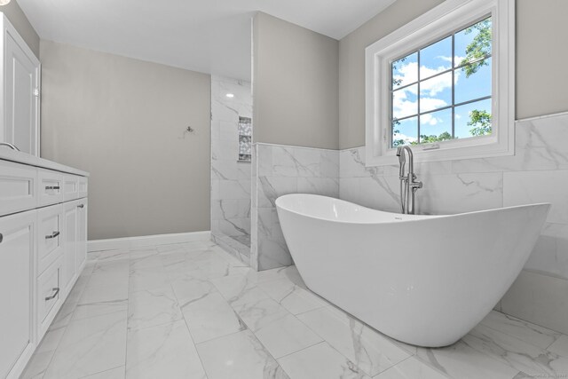 289 Young St, East Hampton, CT 06424 - full bath featuring a freestanding tub, a wainscoted wall, marble finish floor, tile walls, and vanity