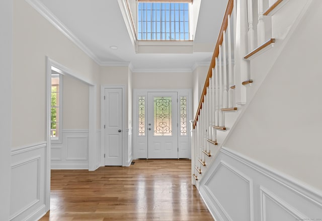 289 Young St, East Hampton, CT 06424 - entryway featuring light wood finished floors, stairs, ornamental molding, wainscoting, and a decorative wall