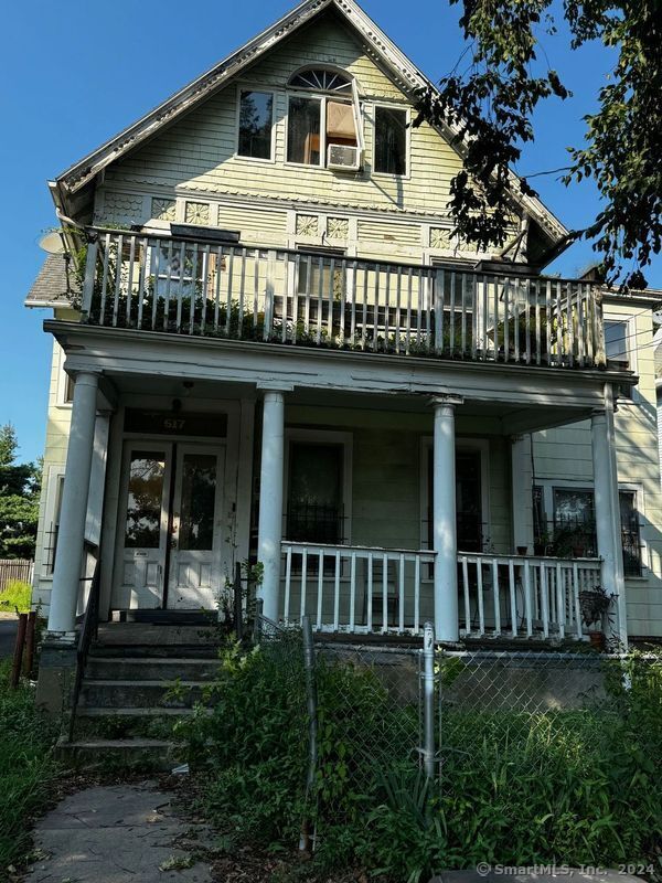 view of front of house featuring cooling unit, covered porch, and a balcony