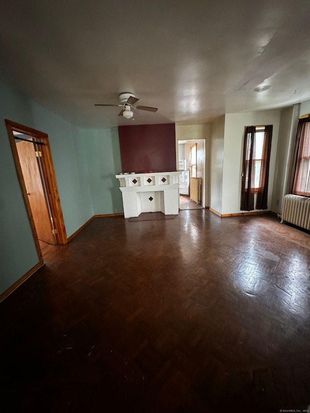 unfurnished living room featuring ceiling fan and radiator