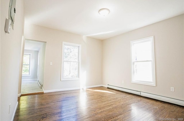 empty room with a baseboard radiator and dark hardwood / wood-style flooring