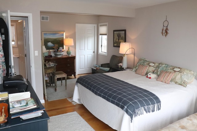 bedroom with wood finished floors and visible vents