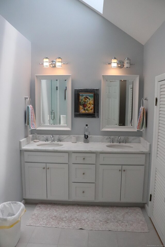 bathroom with tile patterned flooring, lofted ceiling, and vanity