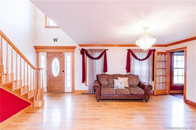 foyer entrance featuring crown molding, a chandelier, and light wood-type flooring