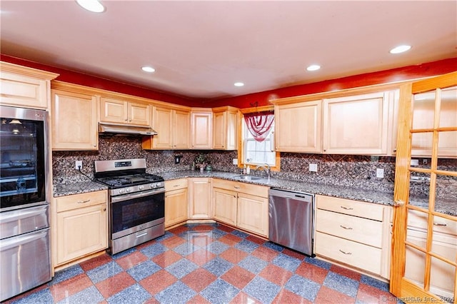 kitchen with backsplash, sink, appliances with stainless steel finishes, tile patterned floors, and light brown cabinets