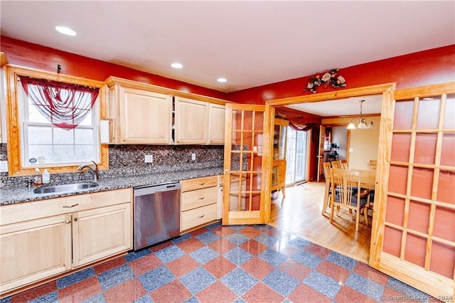 kitchen featuring backsplash, pendant lighting, wood-type flooring, dishwasher, and sink