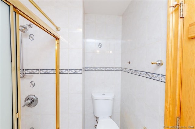 bathroom featuring tile walls, a shower with shower door, and toilet