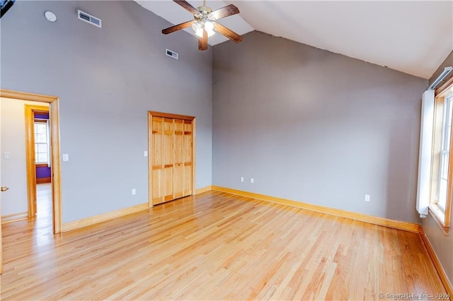 unfurnished room featuring light wood-type flooring, high vaulted ceiling, and ceiling fan